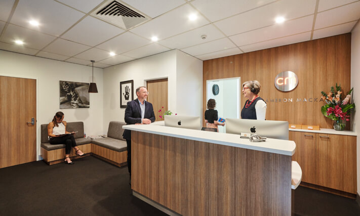 Dr Cameron Mackay at reception area in his clinic 02